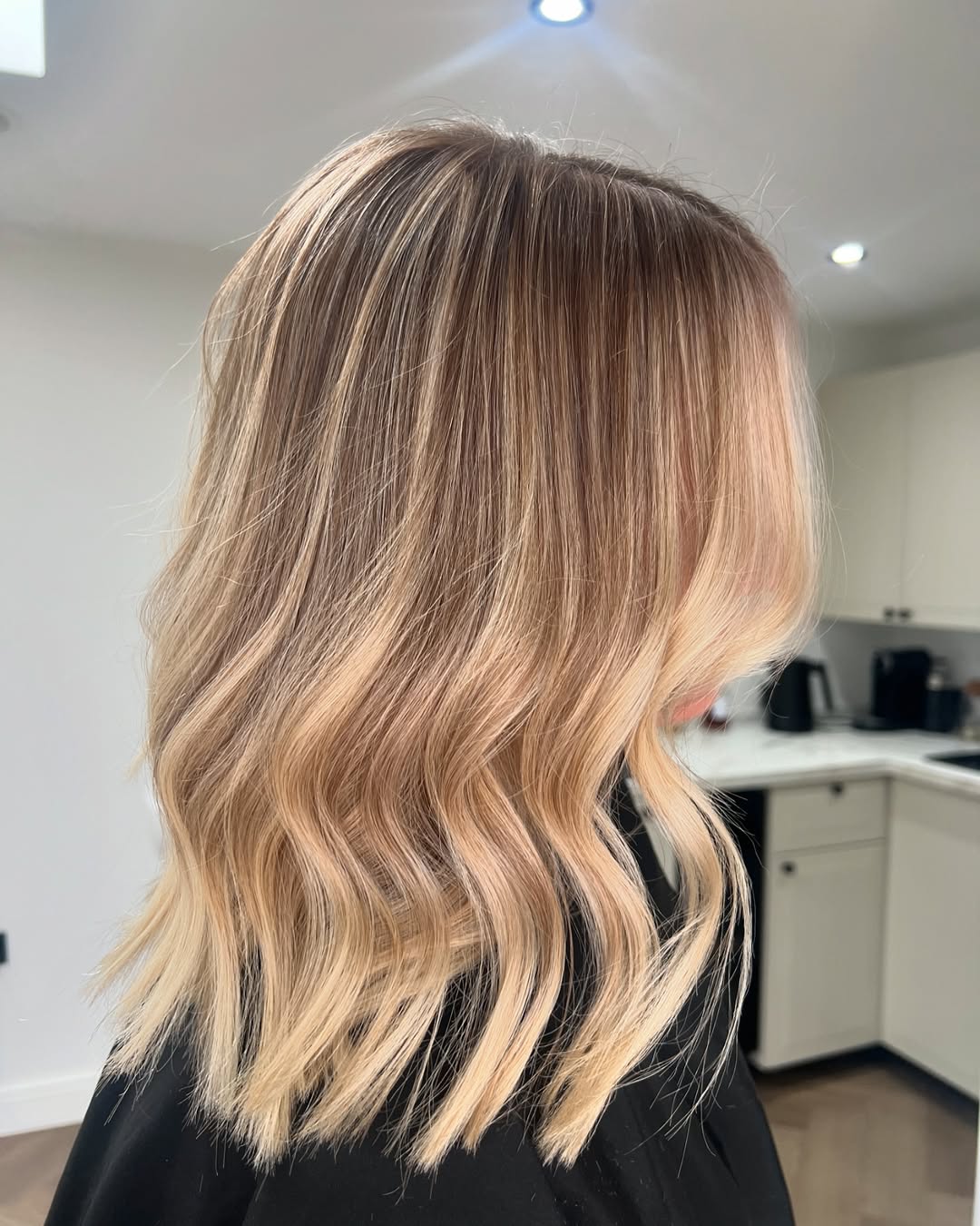 coloration blond crème au beurre sur cheveux légèrement ondulés, tendance 2026