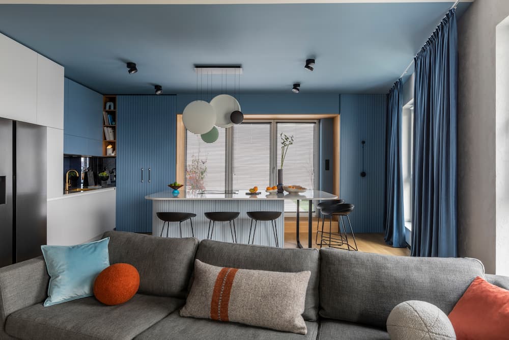espace contemporain bleu cuisine ouverte îlot central touches chaleureuses design moderne