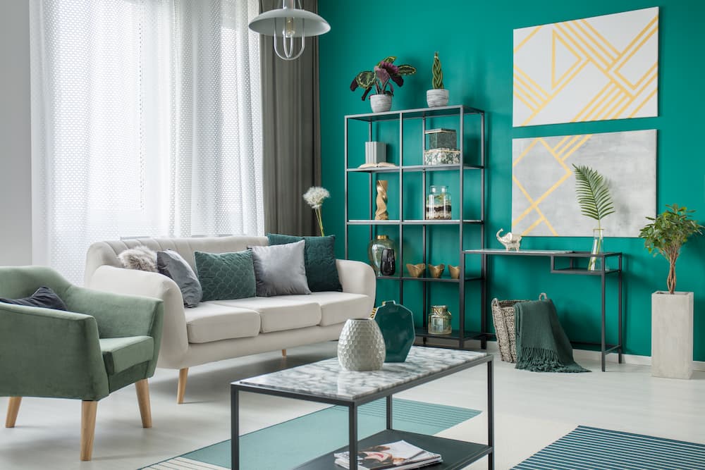 salon lumineux vert émeraude mobilier épuré accents dorés atmosphère fraîche contemporaine