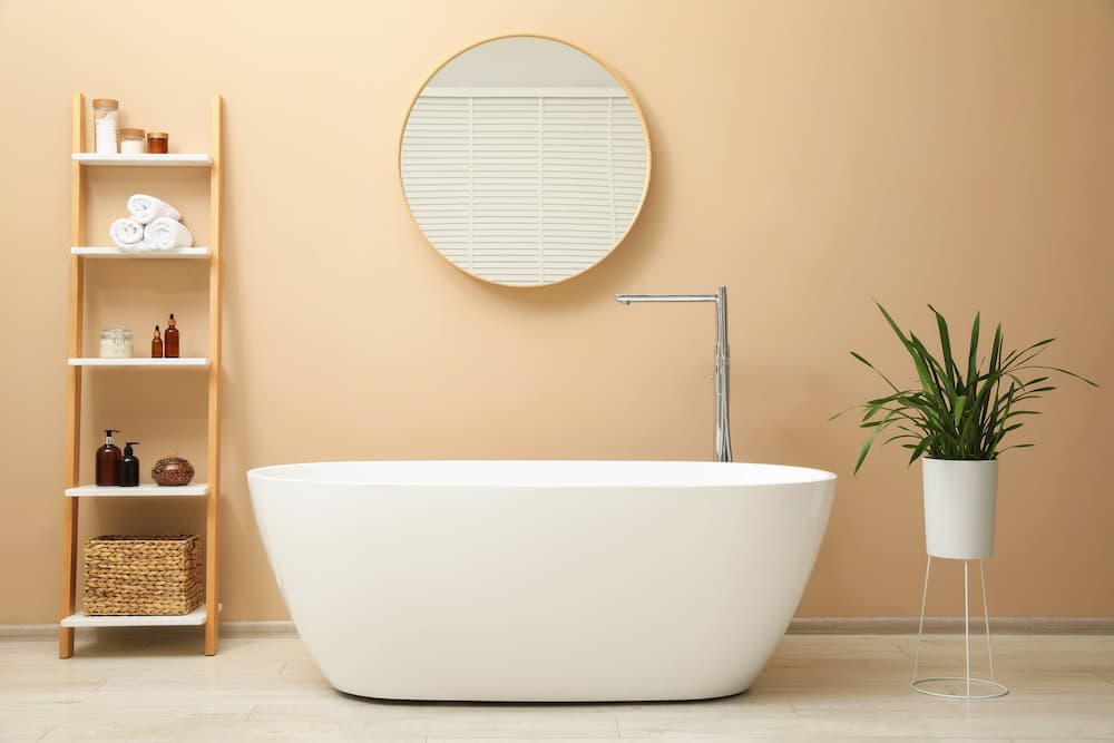 salle de bain épurée murs beige chaud, baignoire blanche bois clair ambiance douce et naturelle