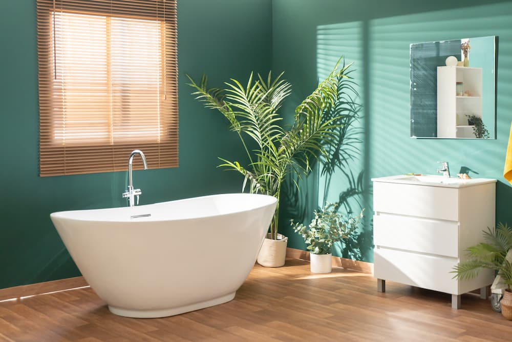 salle de bain lumineuse peinture murale vert émeraude baignoire blanche bois chaud