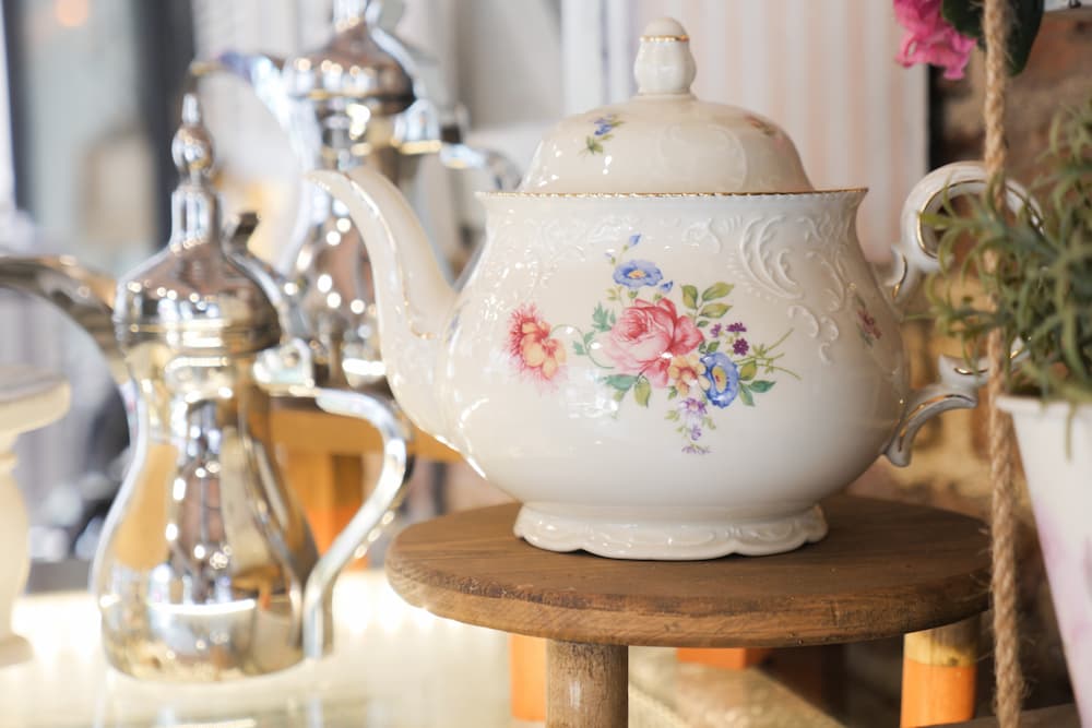 théière florale vintage blanche posée sur tabouret ambiance élégante et rétro