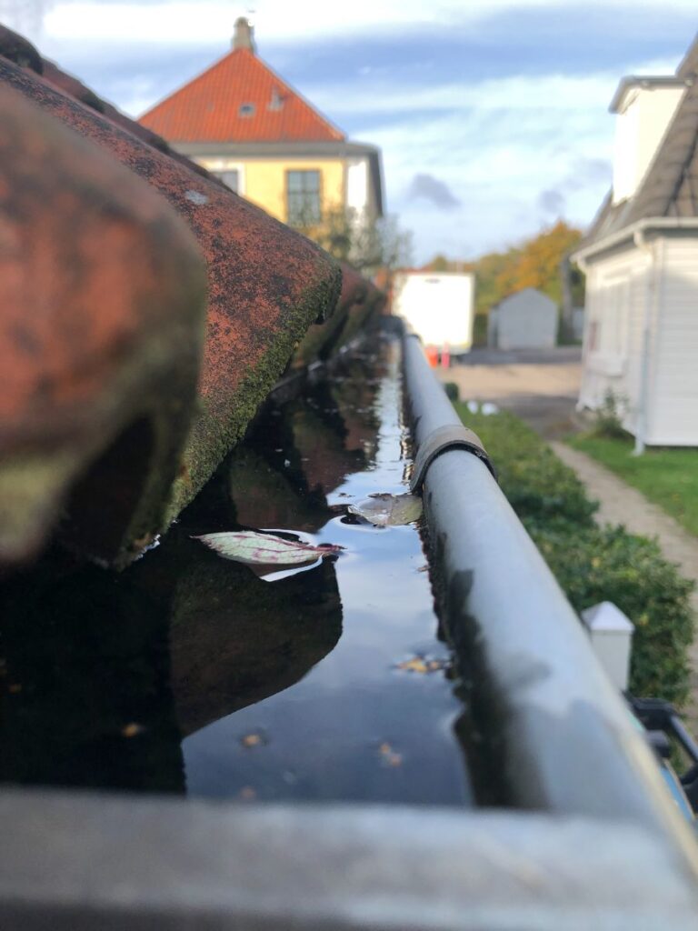 une gouttière et un récupérateur d'eau pour gérer l'eau de pluie