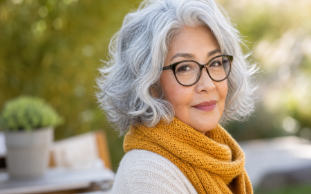 Femme 70 ans avec carré court argenté ondulé et lunettes noires élégantes en plein air