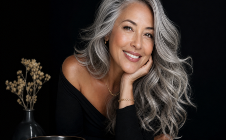 Femme aux longs cheveux gris argentés avec mèches lumineuses, sourire confiant, portrait beauté éditorial