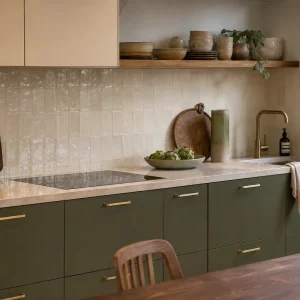 Cuisine contemporaine vert olive avec plan de travail pierre claire et accessoires laiton, tendance 2026