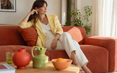Salon français lumineux avec canapé terracotta, blazer en lin jaune beurre et accessoires vert pistache et rouge tomate