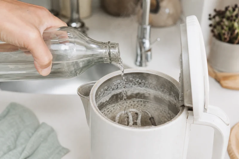 Vinaigre blanc versé dans une bouilloire entartrée pour la détartrer