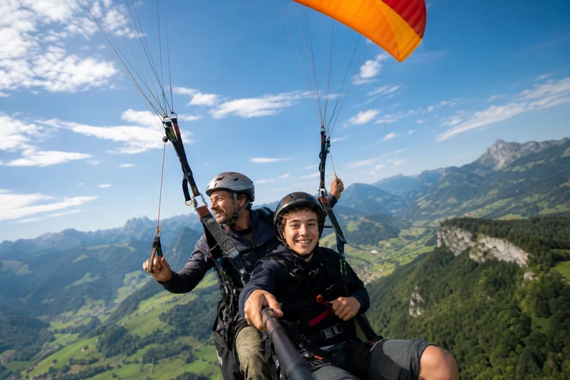 Père et fils en parapente biplace au-dessus des Alpes pour la Fête des Pères
