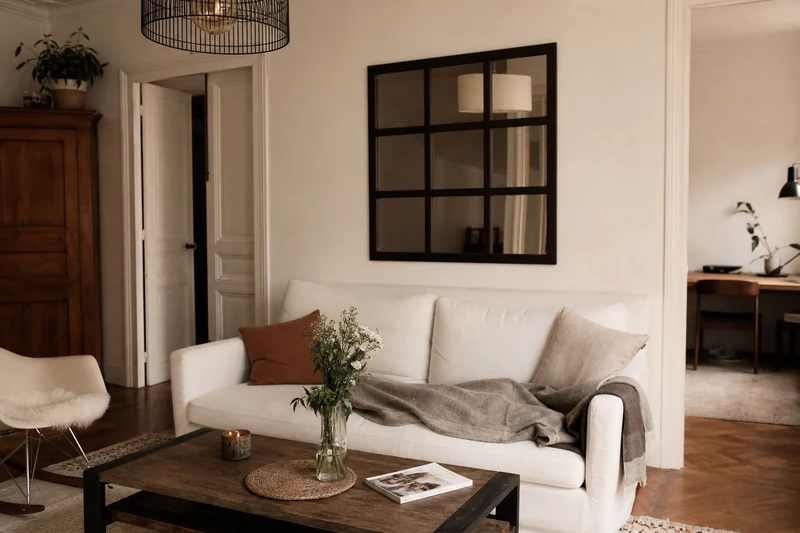 Façade d'immeuble haussmannien aux volets blancs fermés en pleine journée de chaleur