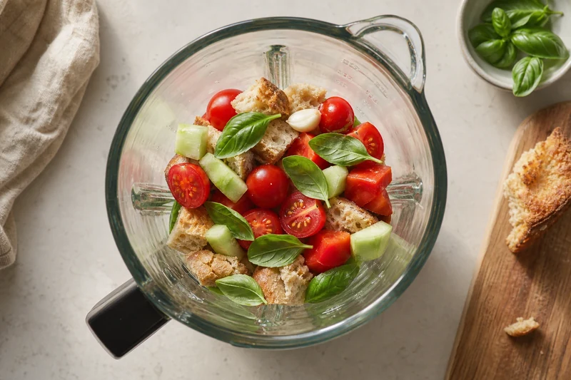 Légumes du gaspacho prêts à être mixés dans un blender en verre
