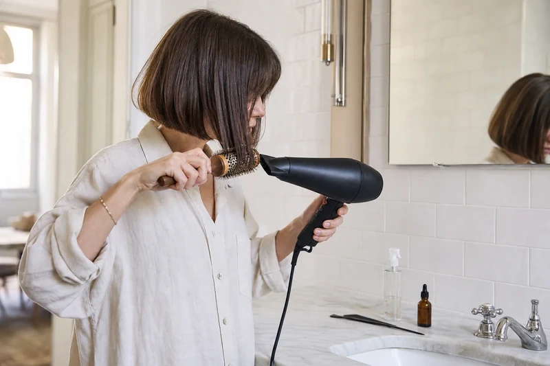 Brushing des pointes d'un Japanese Bob à la brosse ronde, geste enroulé vers l'intérieur