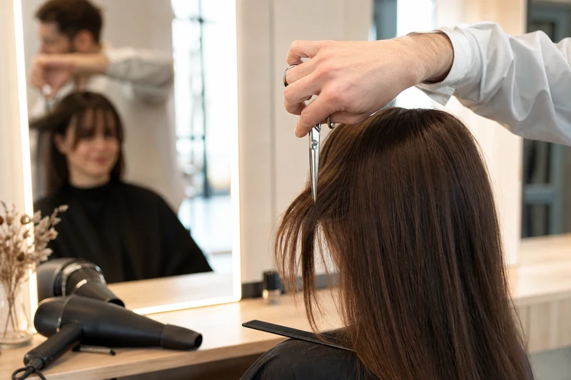 Coiffeur effilant à la verticale une frange U Bang sur cheveux secs