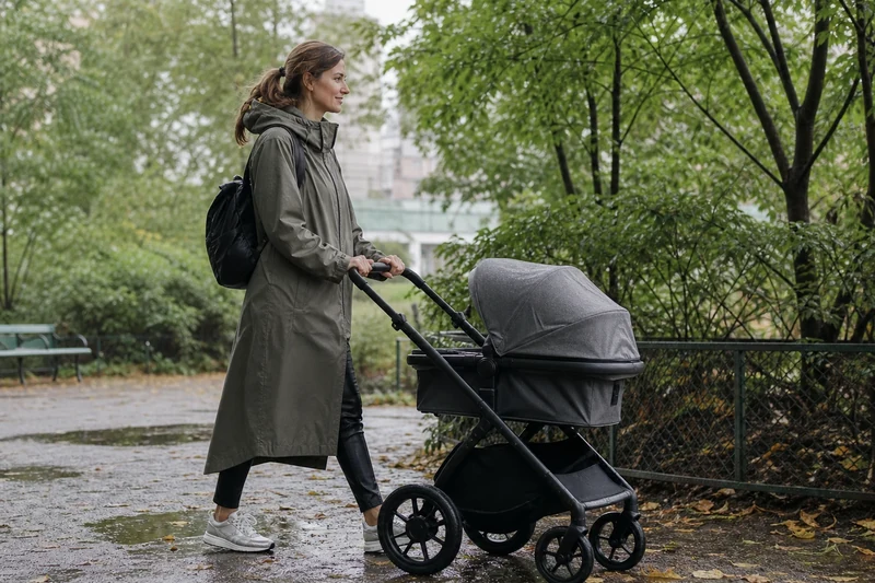 Cape de pluie kaki, pantalon simili-cuir noir et baskets imperméables en parc
