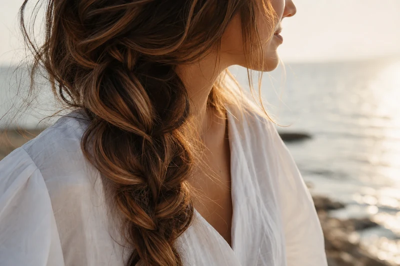 Tresse bohème lâche sur cheveux balayés toffee chocolat en bord de mer