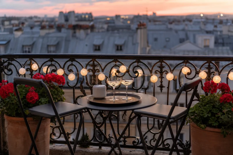 Petit balcon parisien aménagé pour la Fête de la Musique avec guirlande et mobilier pliant