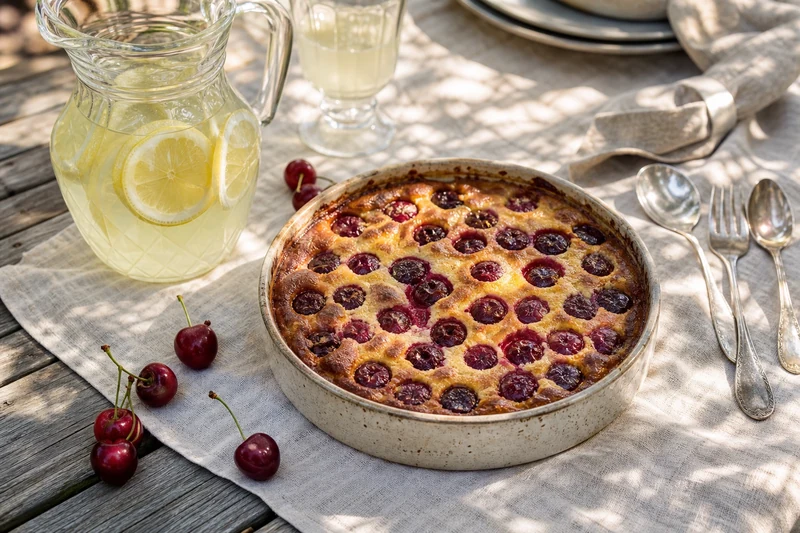 Clafoutis aux cerises servi sur une table d'été en terrasse à la française