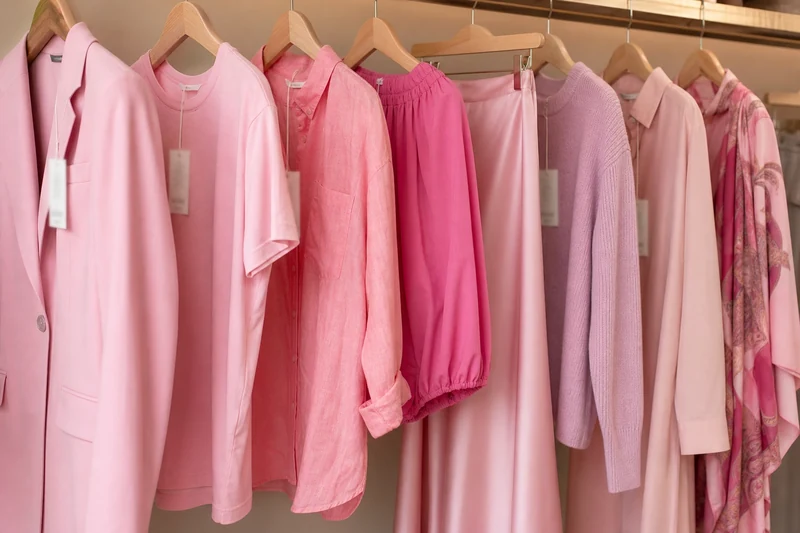 Sélection de huit pièces roses sur cintres dans une boutique mode française