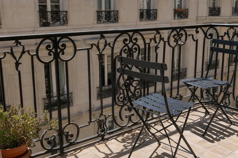 Balcon parisien plein sud sans ombre, mobilier noir surchauffé en plein soleil