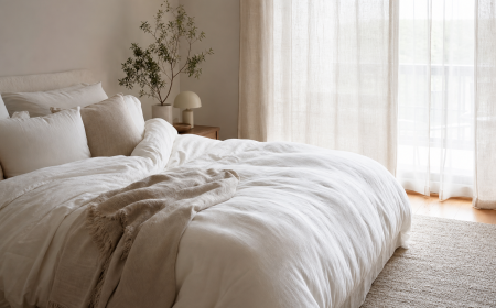 Lit confortable avec couette épaisse et linge de lit naturel dans une chambre lumineuse