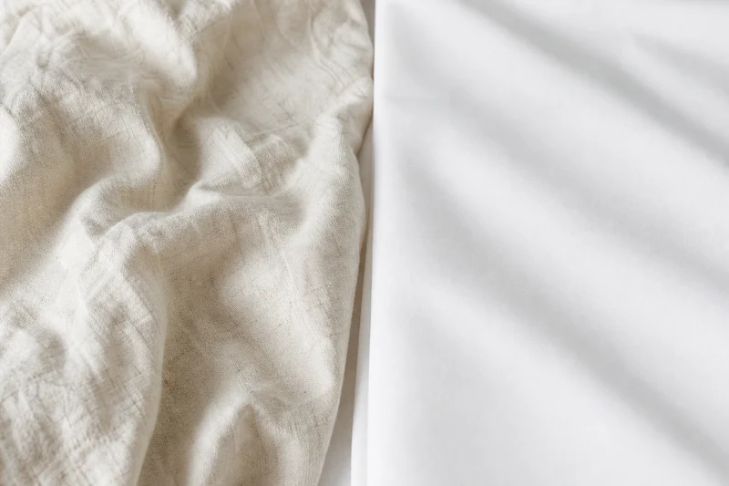 Comparaison macro entre lin lavé écru froissé et coton blanc lisse