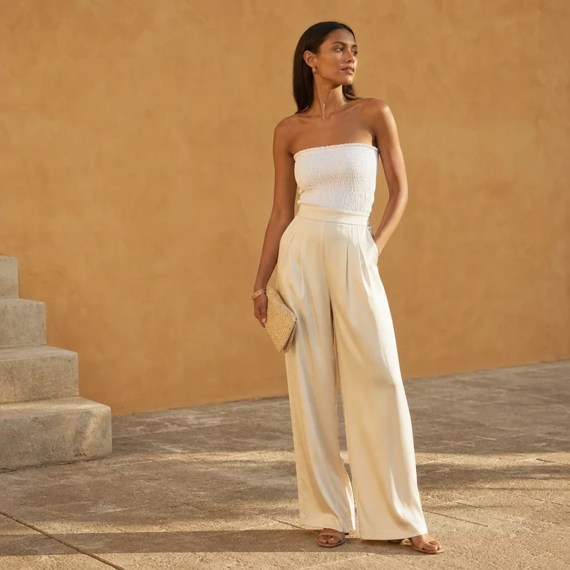 Tenue de dîner d'été avec pantalon large ivoire et top bustier blanc