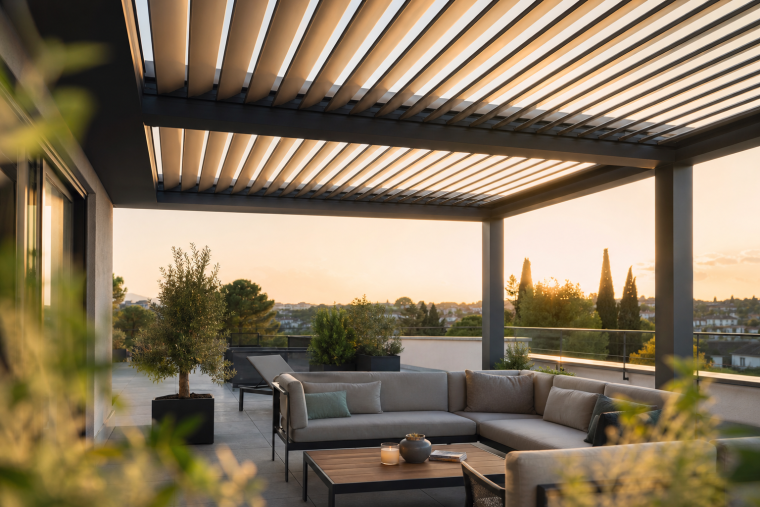 Terrasse moderne avec pergola bioclimatique à lames orientables au coucher du soleil