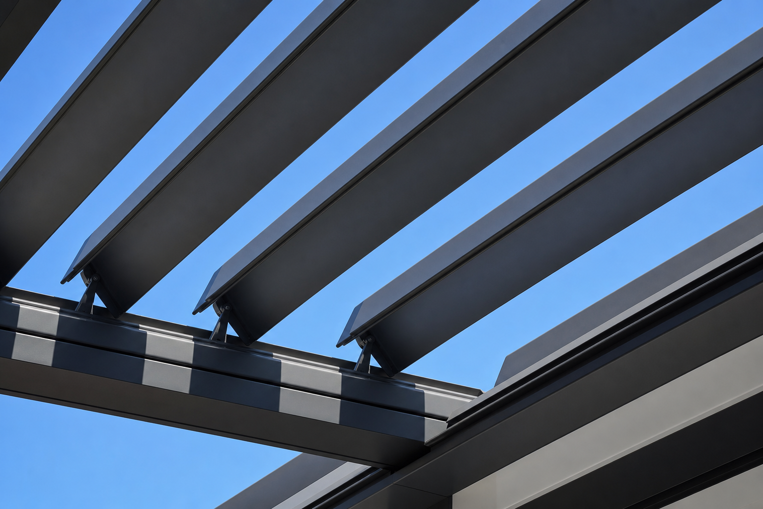 Lames orientables en aluminium d'une pergola bioclimatique contre un ciel bleu