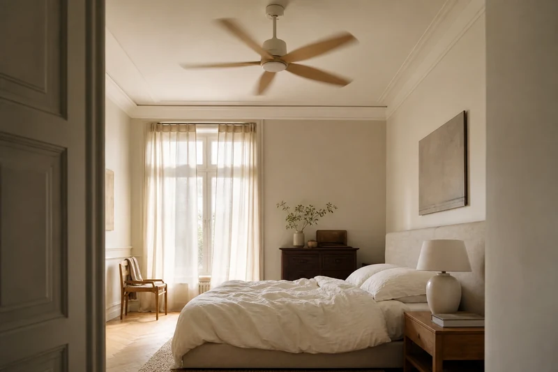 Brasseur d'air plafonnier en bois au-dessus d'un lit dans une chambre française