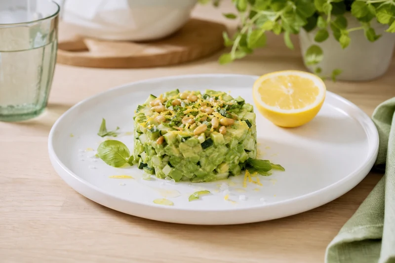 Tartare courgette-avocat-citron dressé en cercle sur assiette blanche