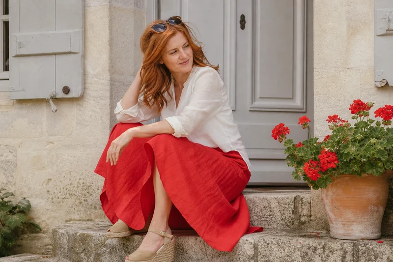 Jupe en lin rouge coquelicot et top blanc, look estival sur un perron