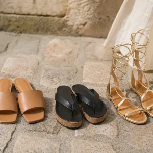 Trois sandales plates tendance été 2026 : mule camel, tong cuir noir compensée, spartiate dorée.