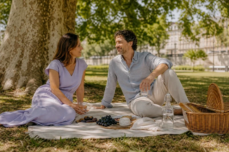Pique-nique estival en vêtements de lin sous un grand platane