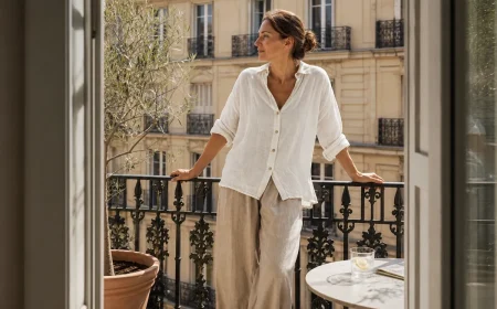Femme en tenue de lin écru sur un balcon parisien lumineux