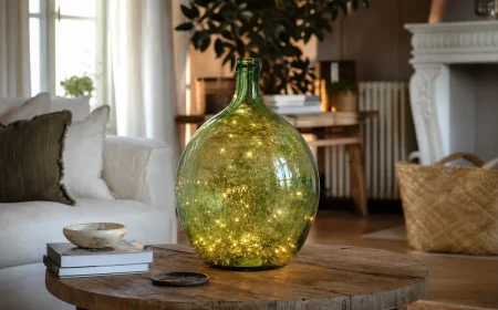 Dame-jeanne en verre vert illuminée par une guirlande LED dans un salon français chaleureux