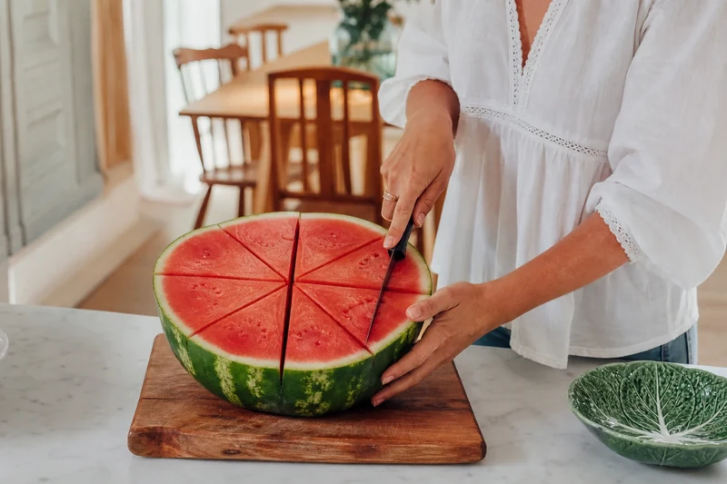 Découpe d'une demi-pastèque en huit parts égales avant la présentation en fleur de lotus