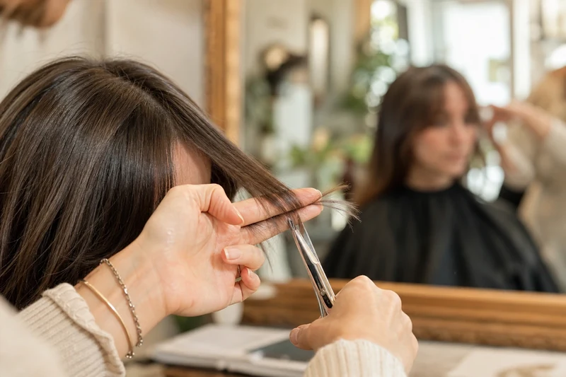 Coiffeur exécutant le dégradé au piqueté sur une frange rideau