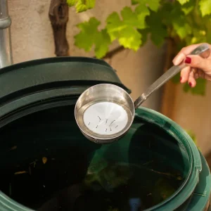 Larves de moustique visibles à la surface de l'eau d'un récupérateur de pluie de jardin