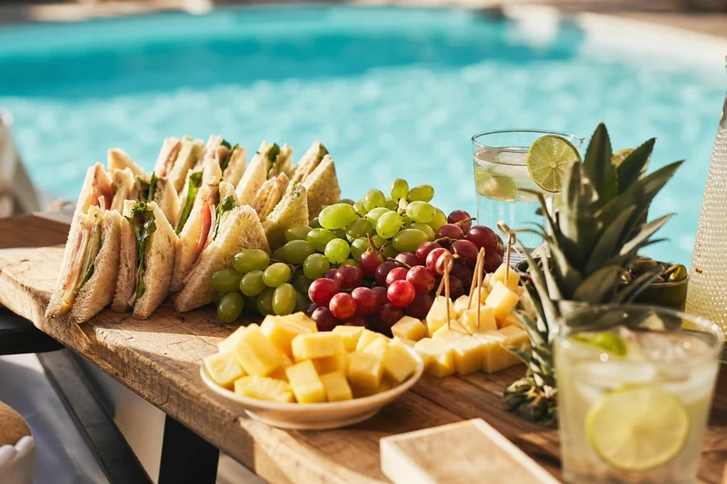 Planche de sandwiches-tongs présentée en bord de piscine pour une pool party estivale