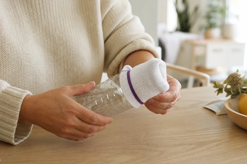 Chaussette blanche en bouclette fixée à la bouteille avec un élastique large