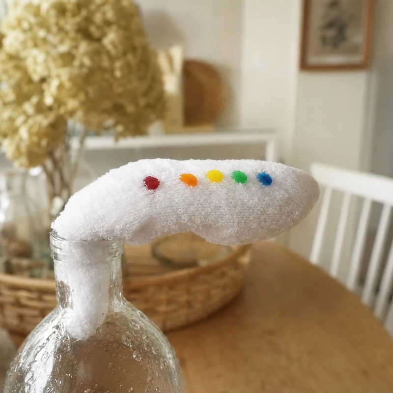 Cinq gouttes de colorant alimentaire alignées en arc-en-ciel sur la chaussette humide