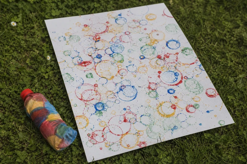 Feuille de papier au sol imprimée par les empreintes colorées des bulles éclatées